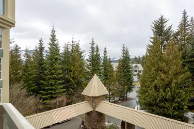 a christmas tree on a balcony with trees at 2BR plus Den in Woodrun, True Ski In, Ski Out, Heated Floors, Pool and Hot Tub, King Ensuite in Whistler
