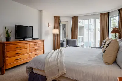 a bedroom with a bed and a tv on a dresser at 2BR plus Den in Woodrun, True Ski In, Ski Out, Heated Floors, Pool and Hot Tub, King Ensuite in Whistler