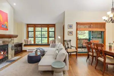 a living room with a couch and a fireplace at 3BR in The Woods, Private Hot Tub, Wood Burning Fireplace, King Ensuite, Private Garage in Whistler