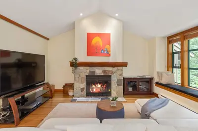 a living room with a fireplace and a tv at 3BR in The Woods, Private Hot Tub, Wood Burning Fireplace, King Ensuite, Private Garage in Whistler