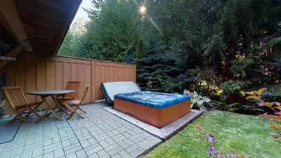 a backyard with a hot tub and a table and chairs at 3BR in Montbello, Cozy Townhouse, Private Hot Tub, Near Village, Fireplace in Whistler