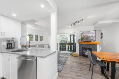 a kitchen and dining room with a table and a fireplace at 3BR in Lagoons, King Bed, Private Balcony, Village Location, Parking in Whistler