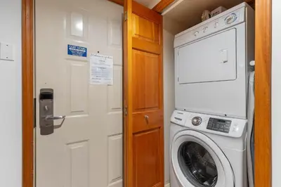a washing machine in a small room with a door at 1BR in Northstar, Village Location, Shared Pool and Hot Tub, Ski Storage, Free Parking in Whistler