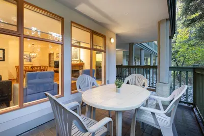 a porch with a white table and chairs at 1BR in Northstar, Village Location, Shared Pool and Hot Tub, Ski Storage, Free Parking in Whistler