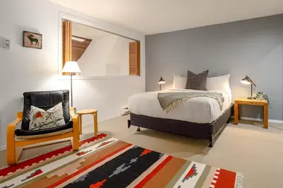 a bedroom with a bed and a chair in it at 2BR plus Den in The Gables, Dog Friendly, Near Both Mountains, Wood Burning Fireplace, Free Parking in Whistler