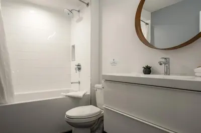 a bathroom with a toilet and a sink and a mirror at 2BR plus Den in The Gables, Dog Friendly, Near Both Mountains, Wood Burning Fireplace, Free Parking in Whistler
