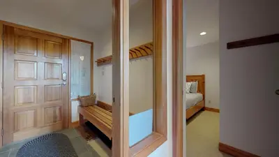 a room with a sliding glass door and a bedroom at 3BR in Alpine Greens, Ski Storage, Wood Burning Fireplace, Free Ski Shuttle in Whistler