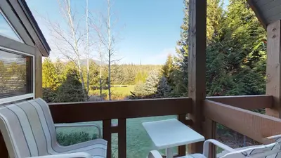 a screened in porch with two chairs and a table at 3BR in Alpine Greens, Ski Storage, Wood Burning Fireplace, Free Ski Shuttle in Whistler