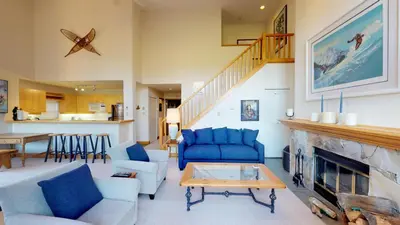 a living room with blue furniture and a fireplace at 3BR in Alpine Greens, Ski Storage, Wood Burning Fireplace, Free Ski Shuttle in Whistler