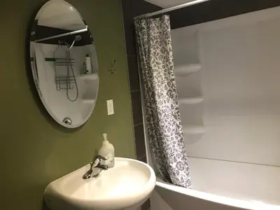 a bathroom with a sink and a mirror and a shower at Private Rooms in a 3 Bedroom Guest House Close to Kingsway NAIT 1 Person per Room No Couples For Men Only in Edmonton