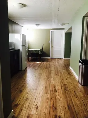 an empty room with wooden floors and a refrigerator at Private Rooms in a 3 Bedroom Guest House Close to Kingsway NAIT 1 Person per Room No Couples For Men Only in Edmonton