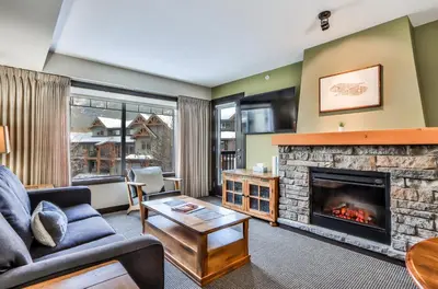 a living room with a couch and a fireplace at SCENIC 1 Bedroom plus Den, PET FRIENDLY managed by Little Sister Getaways in Dead Man's Flats