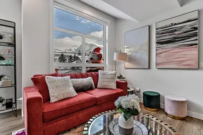 a living room with a red couch and a window at The Parq by Samsara Resort Top View Downtown 4BR & 3BTH in Canmore