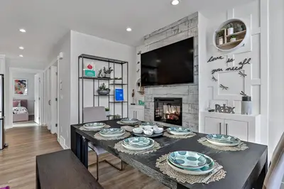 a dining room with a table and a fireplace at The Parq by Samsara Resort Top View Downtown 4BR & 3BTH in Canmore