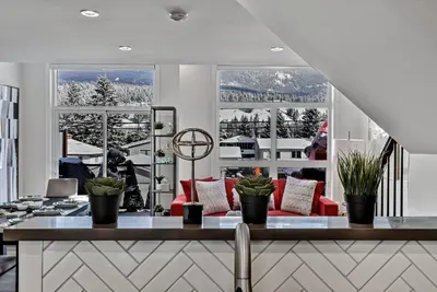 a living room with a view of a snowy mountain at The Parq by Samsara Resort Top View Downtown 4BR & 3BTH in Canmore