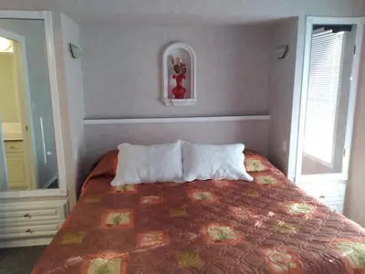 a bedroom with a bed with two pillows and a mirror at Fairmont Mountain View Villas in Fairmont Hot Springs