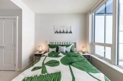 a bedroom with a large bed with green leaves on it at UBC Pacific Spirit Modern Style Home in Vancouver
