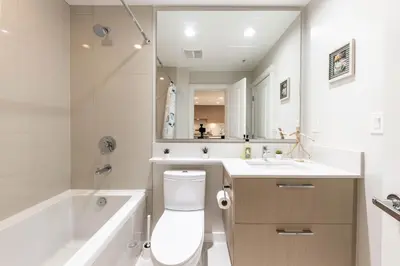 a bathroom with a toilet and a tub and a sink at UBC Pacific Spirit Modern Style Home in Vancouver