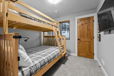 a bedroom with two bunk beds and a tv at Echo Landing #42 by Bear Country in Sun Peaks