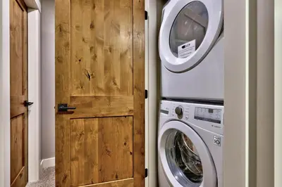a laundry room with a washer and dryer next to a door at Echo Landing #42 by Bear Country in Sun Peaks