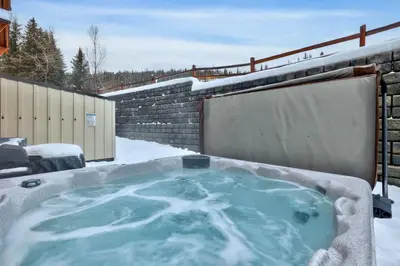 a jacuzzi tub in the snow in a yard at Echo Landing #42 by Bear Country in Sun Peaks