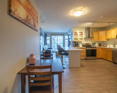 a kitchen with a table and chairs in a room at Top Floor Condo - 2BR & AC with Mountain Views in Canmore