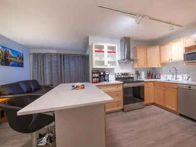 a kitchen with a white counter top and wooden cabinets at Top Floor Condo - 2BR & AC with Mountain Views in Canmore