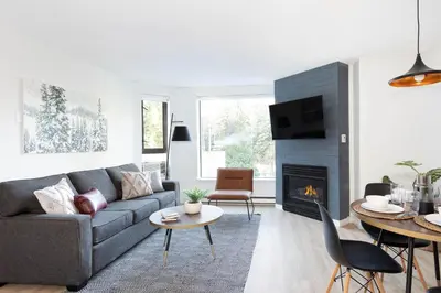 a living room with a couch and a fireplace at Contemporary & Spacious Slopeside 1BR Getaway in Whistler