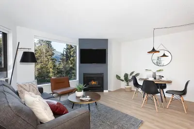 a living room with a couch and a fireplace at Contemporary & Spacious Slopeside 1BR Getaway in Whistler