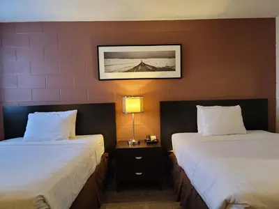 a hotel room with two beds and a picture on the wall at Roadking Inns Motel in Calgary