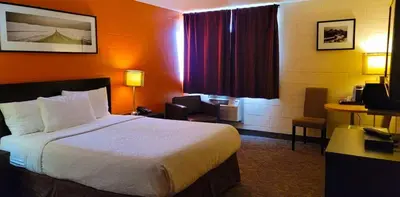a hotel room with a bed and a desk at Roadking Inns Motel in Calgary