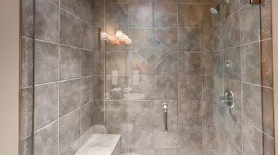 a bathroom with a shower with a person in it at I Spy - Cozy Pet Friendly, Ski In Ski Out Condo with Private Hot Tub in Big White