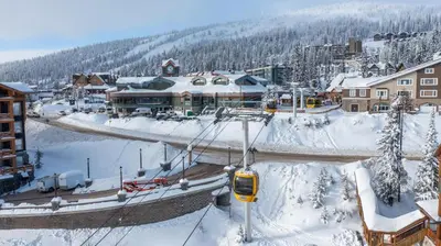 a ski resort in the snow with a tram at I Spy - Cozy Pet Friendly, Ski In Ski Out Condo with Private Hot Tub in Big White