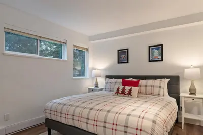 a bedroom with a bed and two windows at 3BR in Valhalla, Village Location, Communal Hot Tub, Gas Fireplace, Parking in Whistler