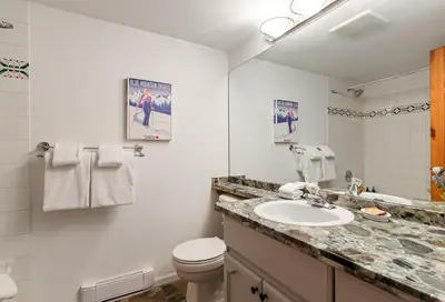 a white bathroom with a sink and a toilet at 3BR in Valhalla, Village Location, Communal Hot Tub, Gas Fireplace, Parking in Whistler