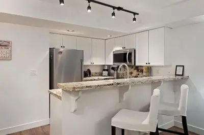a kitchen with a refrigerator and white cabinets at 3BR in Valhalla, Village Location, Communal Hot Tub, Gas Fireplace, Parking in Whistler