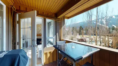 a balcony with a glass table and a window at 1BR and Den in Marketplace Lodge, Gas Fireplace, Village Location, Complex Hot Tub in Whistler