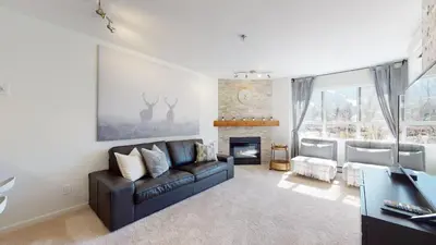 a living room with a couch and a fireplace at 1BR and Den in Marketplace Lodge, Gas Fireplace, Village Location, Complex Hot Tub in Whistler