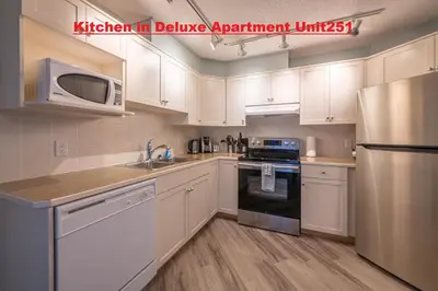 a kitchen with white cabinets and a stainless steel refrigerator at Windtower Lodge - Canmore in Canmore