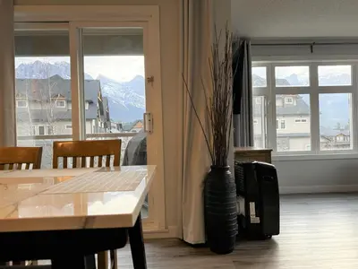 a vase with a plant in a room with a table at Windtower Lodge - Canmore in Canmore