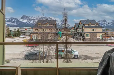 a window with a view of a street and mountains at Windtower Lodge - Canmore in Canmore