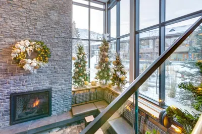 a lobby with christmas trees and a fireplace at Peaks Hotel and Suites in Banff