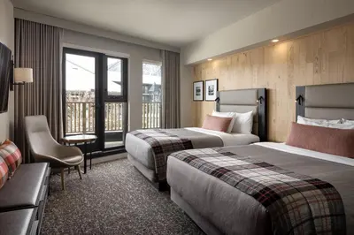 a hotel room with two beds and a window at Peaks Hotel and Suites in Banff