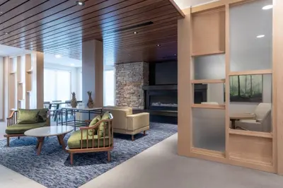 a lobby with chairs and a table and a fireplace at Fairfield by Marriott Inn & Suites Revelstoke in Revelstoke