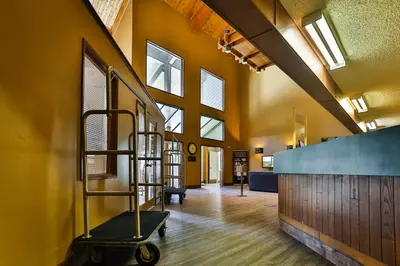 a hallway with a staircase in a building with windows at Griz Inn by StayIn in Fernie