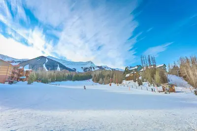 a skier is skiing down a snow covered slope at Griz Inn by StayIn in Fernie