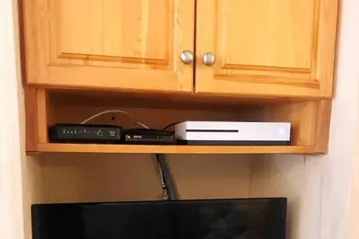 a cabinet with a tv and a router and other items at MountainView -PrivateChalet Sleep7- 5min to DT Vacation Home in Canmore