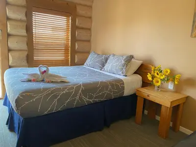 a bedroom with a bed with a stuffed animal on it at Bear's Claw Lodge in Cache Creek