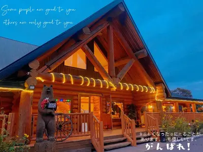 a bear standing in front of a log cabin at Bear's Claw Lodge in Cache Creek