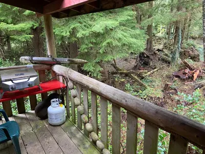 a porch with a grill and a picnic table on it at Woods End Landing in Bamfield